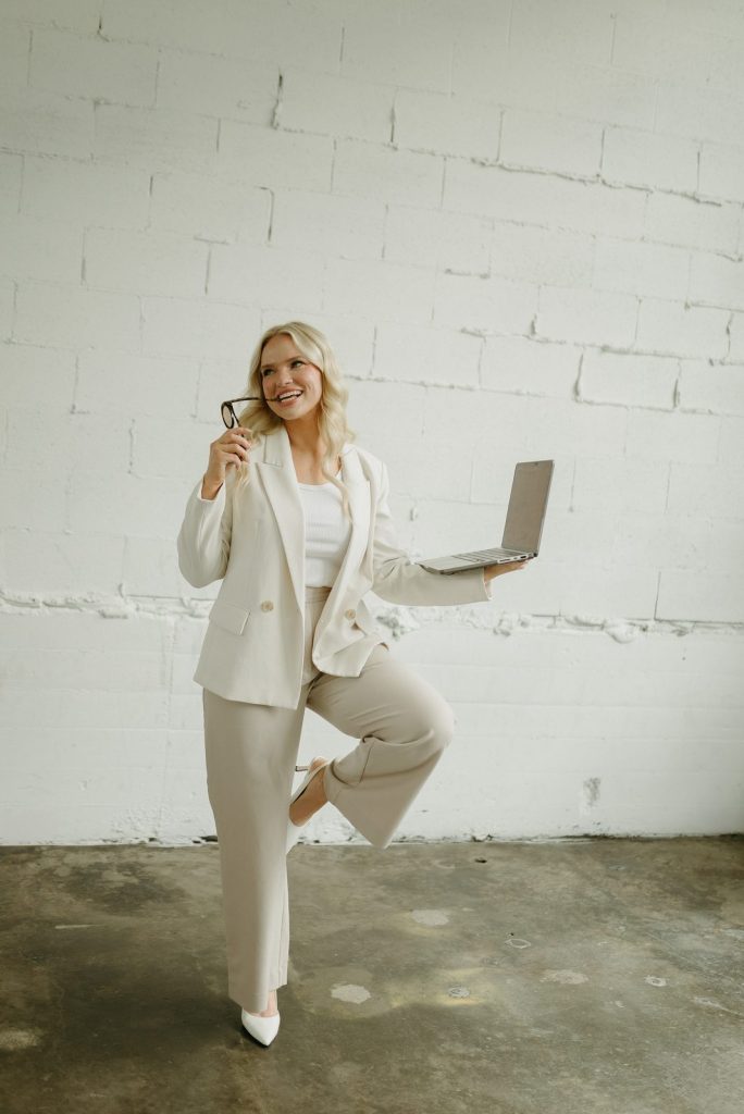 Riley Button of R Collective Media holding a laptop