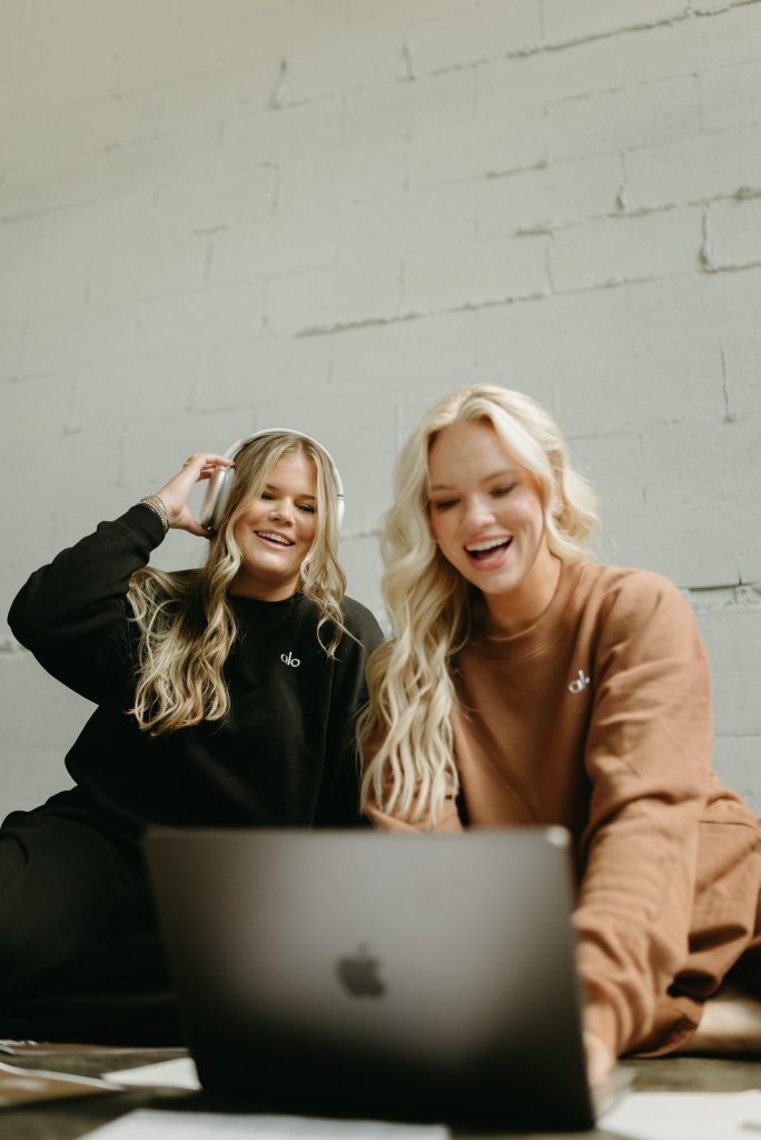Riley and Paige laughing while working on social media content